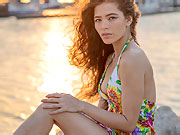 Cute Irene Rouse posing on the beach in her short color summer dress